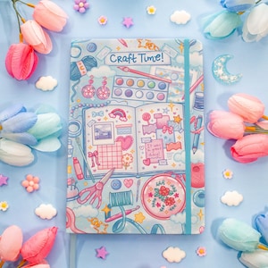 May include: A light blue journal with the text "Craft Time!" and illustrations of craft supplies. The journal is surrounded by pink and blue tulips, and decorative embellishments.