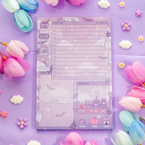 May include: A lavender-colored notepad with a whimsical design, featuring a "To Do List" section, illustrations of a ghost, bats, and a carnival scene. Decorative elements include flowers and star-shaped embellishments.