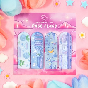 May include: Three pastel blue page flags with different designs. The first flag features a hydrangea flower, the second a stack of books, and the third a crescent moon and stars. The flags are on a pink background with the text "Unicorn Eclipse Page Flags".