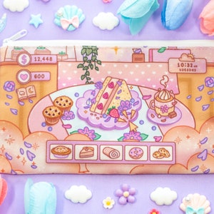 May include: A rectangular pencil case with a zipper closure. The case features a colorful illustration of a dessert-themed video game interface. The design includes images of pastries, a coffee cup, and a cake, all set against a pastel background.