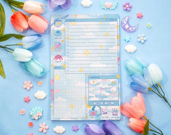 May include: A blue and white planner with a cloud and star design. The planner has sections for to-do lists, notes, and a daily schedule. The planner is surrounded by pastel-colored flowers and decorative accents.