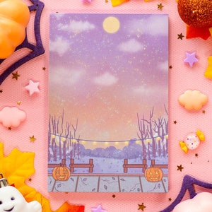 May include: A printable card featuring a whimsical illustration of a nighttime scene with two jack-o'-lanterns, trees, and a starry sky. The card is perfect for Halloween or fall-themed crafts.