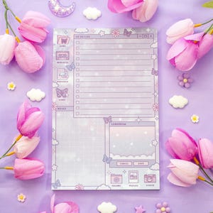 May include: A lilac notepad with a dreamy design, featuring a to-do list, notes section, and butterfly and cloud illustrations. The notepad is surrounded by pink tulips, decorative flowers, and a crescent moon.