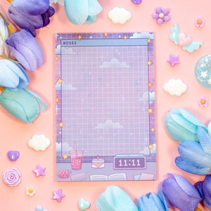 Könnte beinhalten: Ein lila und blauer Notizblock mit einem Rastermuster und einem Nachthimmel-Design. Der Notizblock hat einen weißen Rand und das Wort "NOTES" ist oben links gedruckt. Der Notizblock hat auch eine Uhr mit der Zeit 11:11 darauf gedruckt. Der Notizblock ist von pastellfarbenen Blumen, Wolken und Sternen umgeben.