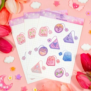 May include: A set of 10 colorful tea bag stickers with a whimsical unicorn theme. The stickers feature various designs, including teacups, stars, and moons. The stickers are printed on a white background with a subtle grid pattern. The text "Unicorn Eclipse" is printed at the top of the sheet.