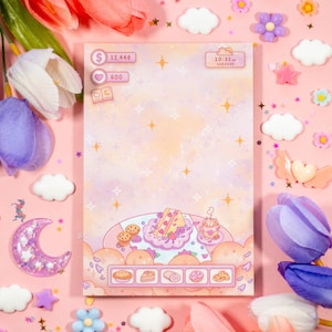 May include: A pink and purple digital planner with a pastel background and a cute illustration of a dessert plate with a slice of cake, a cupcake, and a roll. The planner has a digital clock that reads 10:32 am and the day of the week is Tuesday. The planner also has a digital currency amount of $12,446 and a heart icon with the number 600.