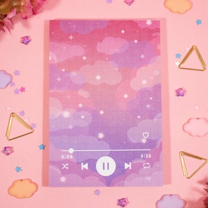 May include: A pink and purple notebook with a cloud and star pattern. The notebook has a music player interface with the text "0:05" and "3:25" on the bottom.