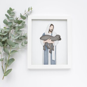Puede incluir: Una ilustraci&oacute;n enmarcada de Jes&uacute;s sosteniendo un cordero en sus brazos. La ilustraci&oacute;n est&aacute; hecha en estilo acuarela con colores apagados. El fondo es blanco.