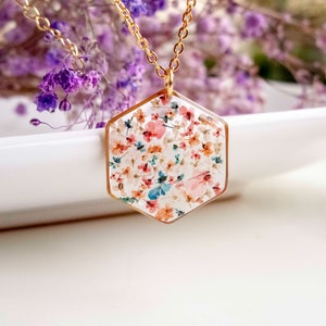 Collier et boucles d'oreilles pendantes avec de fleurs séchées multicolore en résine. Ensemble de bijoux doré en forme de hexagonale. Collier