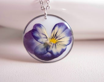 Pensée sur fond blanc, Pendentif rond, Collier fleurs séchées dans un résine, bijoux acier inoxydable.