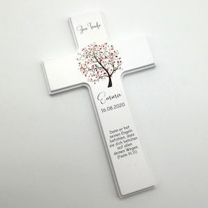 May include: White wooden cross with a stylized tree design in shades of green, pink, and brown. The cross has the text "Zur Taufe" at the top, "Emma" in the center, and "16.08.2020" below the name. The bottom of the cross has a quote in German: "Denn er hat seinen Engeln befohlen, dass sie dich beh&uuml;ten auf allen deinen Wegen. (Psalm 91,11)"