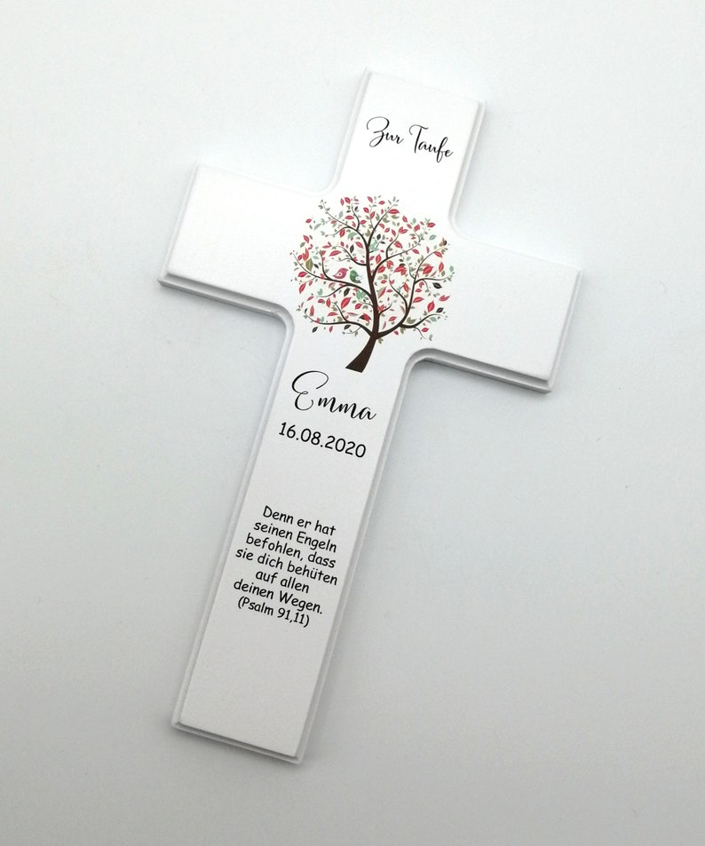 May include: White wooden cross with a pink and green tree design and the text "Zur Taufe" at the top. The name "Emma" and the date "16.08.2020" are printed below the tree. The text "Denn er hat seinen Engeln befohlen, dass sie dich beh&uuml;ten auf allen deinen Wegen. (Psalm 91,11)" is printed at the bottom.