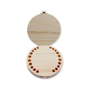 May include: A round wooden box with a hinged lid. The box has a series of small holes around the edge of the bottom.