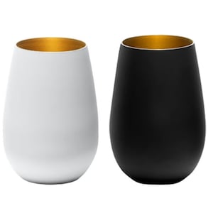 May include: Two wine glasses with gold rims. One glass is white and the other is black.