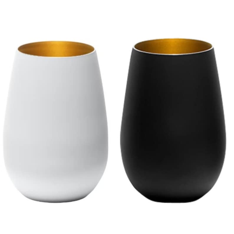 May include: Two wine glasses with gold rims. One glass is white and the other is black.