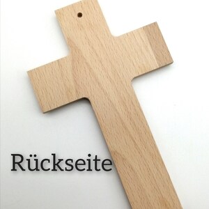 May include: A plain wooden cross with a small hole at the top for hanging. The back of the cross is visible and has the word "R&uuml;ckseite" written on it.