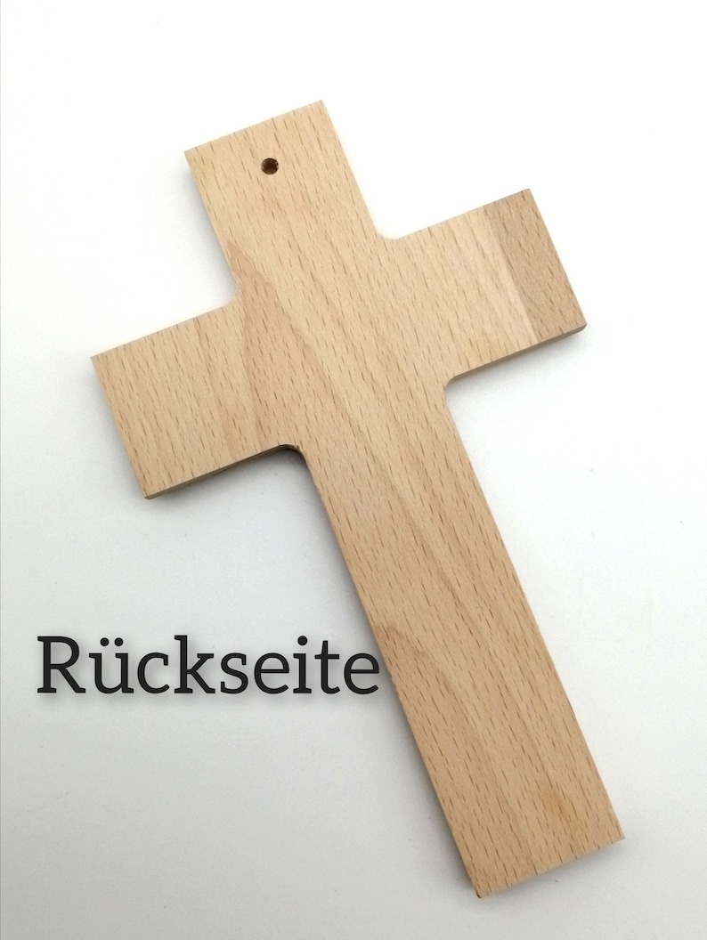 May include: A plain wooden cross with a small hole at the top for hanging. The back of the cross is visible and has the word "R&uuml;ckseite" written on it.