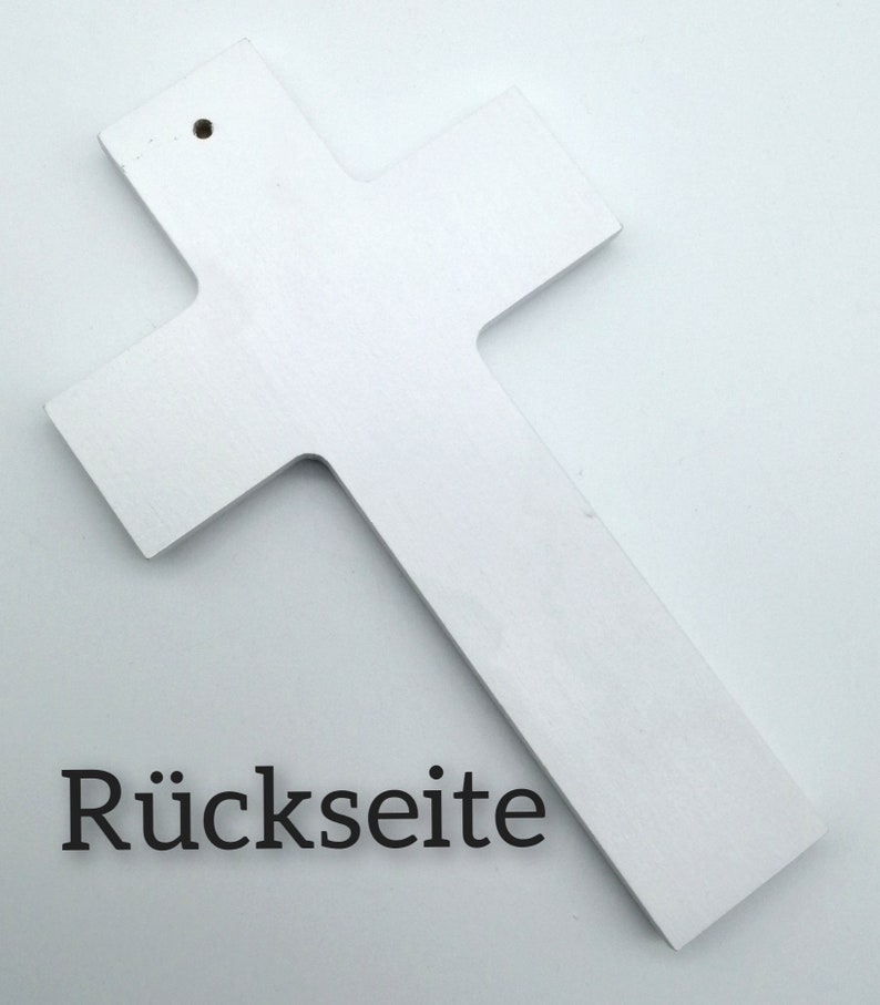 May include: White wooden cross with a hole at the top for hanging. The back of the cross is shown in the image. The text "R&uuml;ckseite" is printed on the bottom of the image.