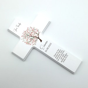 May include: White wooden cross with a pink and green tree design. The cross has the text "Zur Taufe Emma 16.08.2020" and a bible verse.