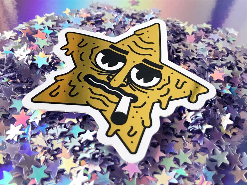 Op de afbeelding: Een gouden sticker in de vorm van een ster met een cartoon gezicht, druipend met een kleverige substantie. Het gezicht heeft een hangende uitdrukking, met &eacute;&eacute;n oog gesloten en het andere wijd open. De ster houdt een sigaret in zijn mond.