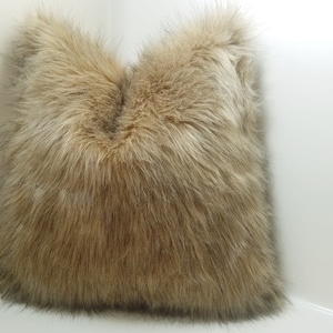 May include: A brown faux fur throw pillow with a soft, fluffy texture.