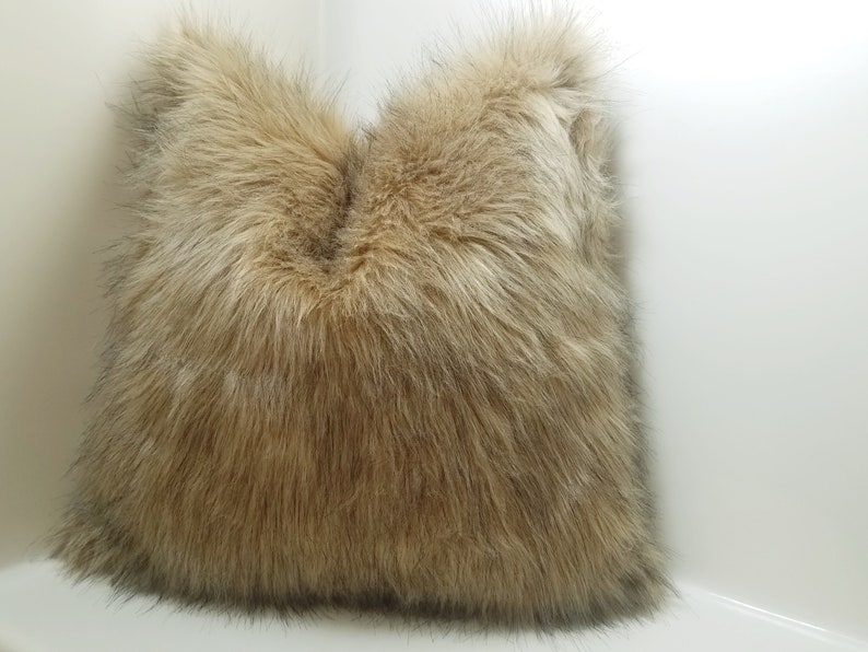 May include: A brown faux fur throw pillow with a soft, fluffy texture.