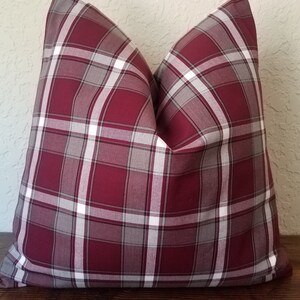 May include: A burgundy, gray, and white plaid pillow cover. The pillow cover is made of a soft, comfortable fabric and has a subtle sheen.
