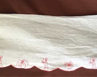 May include: White rectangular kitchen towel with a scalloped edge, featuring red embroidered designs of chefs and food items. The towel is made of a lightweight fabric and is likely used for drying dishes or as a decorative element in the kitchen.