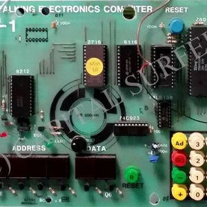Op de afbeelding: Een groene printplaat met verschillende elektronische componenten, waaronder chips, weerstanden en een toetsenbord. De printplaat is gelabeld met "Talking Electronics Computer" en "TEC-1".