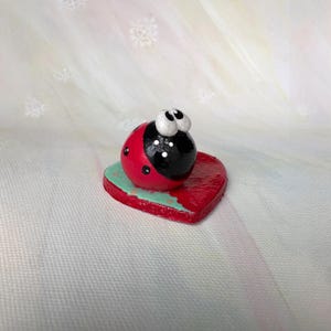 Ladybug Figurine on Red Heart, Whimsical Bug Decor, Clay Miniature Sculpture, Shelf Collectible