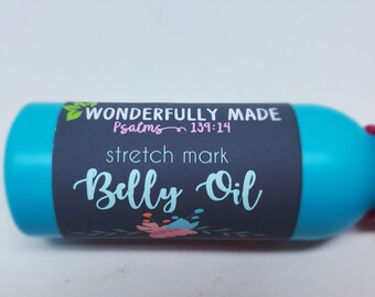 May include: A turquoise blue bottle with a black label that reads "Wonderfully Made Psalms 139:14 stretch mark Belly Oil".
