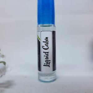 May include: A clear glass roll-on bottle with a blue cap. The label reads "Liquid Calm" in a script font. The bottle contains a clear liquid and is set against a white background.