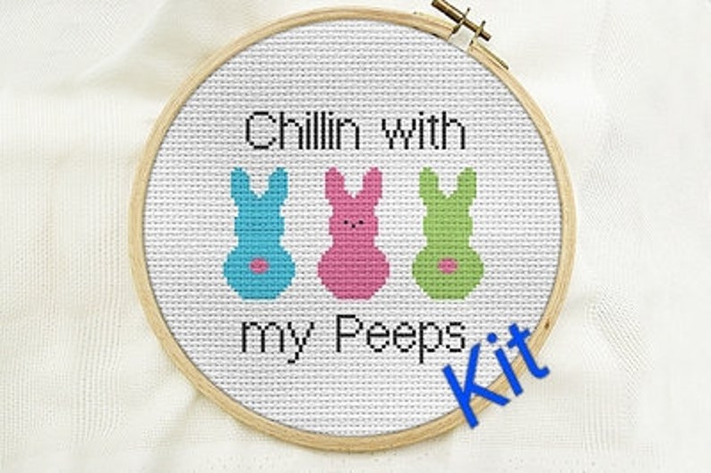 Peut inclure: Kit de point de croix avec trois personnages de marshmallow en forme de lapin de couleur, avec le texte "Chillin' with my peeps".