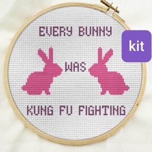 May include: A cross-stitch embroidery kit featuring two pink bunny silhouettes with the text "Every bunny was kung fu fighting".