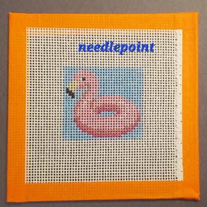 Puede incluir: Lienzo de punto de aguja con un flotador de flamenco rosa sobre un fondo azul. La palabra "needlepoint" está escrita en azul en la parte superior. El lienzo está bordeado con tela naranja.