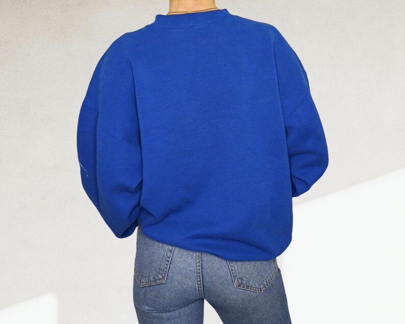 May include: A royal blue sweatshirt with long sleeves and a crew neck.