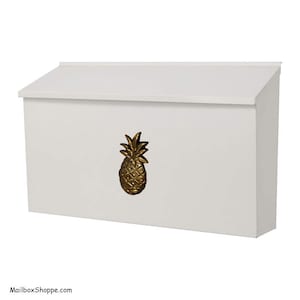 May include: White mailbox with a gold pineapple design. The mailbox has a sloped top and a rectangular opening for mail.