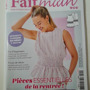 May include: A magazine cover with a woman wearing a pink and white striped top. The magazine is titled "Fait main" with French text. The cover also includes text about sewing and fashion, with a focus on clothing.