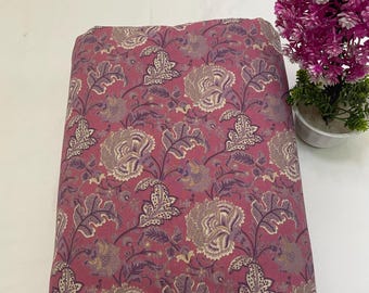 May include: Pink fabric with a floral print featuring a repeating pattern of white and purple flowers with leaves.