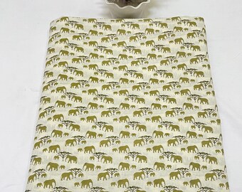 May include: White fabric with a repeating pattern of green elephants and trees. The elephants are in various sizes and positions.