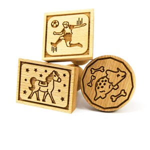 Peut inclure: Trois emporte-pièces en bois, un en forme de dinosaure, un en forme de cheval et un en forme de joueur de football.