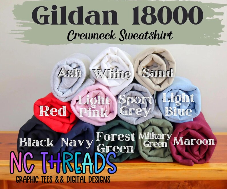 May include: A stack of rolled Gildan 18000 crewneck sweatshirts in various colors, including red, black, navy, and forest green. The image displays the colors Ash, White, Sand, Light Pink, Sport Grey, Light Blue, Military Green, and Maroon. The text "NC THREADS" and "GRAPHIC TEES & DIGITAL DESIGNS" are also visible.