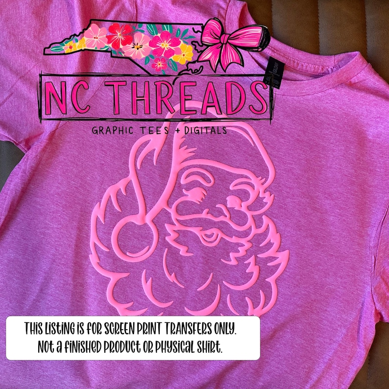 May include: A pink t-shirt featuring a Santa Claus design in a lighter pink hue. The shirt also displays the text "NC THREADS" and "GRAPHIC TEES + DIGITALS". A text box at the bottom states, "THIS LISTING IS FOR SCREEN PRINT TRANSFERS ONLY. NOT A FINISHED PRODUCT OR PHYSICAL SHIRT."