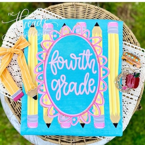 Pode incluir: Uma t-shirt azul brilhante com um padrão repetitivo de lápis amarelos com borrachas cor-de-rosa. Ao centro, uma moldura oval recortada cor-de-rosa contém o texto cursivo rosa claro fourth grade. Um laço às riscas amarelas no lado.
