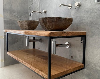 May include: A double sink bathroom vanity with a wooden countertop and black metal frame. The countertop has a shelf underneath. The sinks are made of natural stone and have a rustic look.