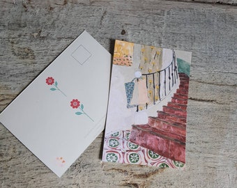 Illustrated postcard of a girl with a bouquet of flowers sitting on a staircase in a garden