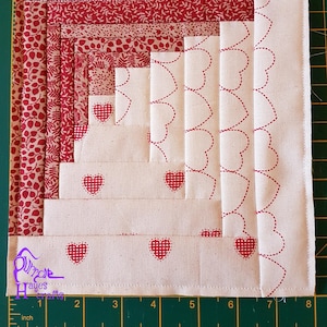 Puede incluir: Un bloque de colcha rojo y blanco con un patrón de corazón. El bloque está formado por varias capas de tela, cada una con un patrón diferente. El bloque mide 20,3 cm de ancho y 20,3 cm de largo.