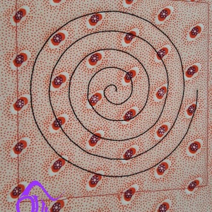 May include: A close-up of a pink fabric with a repeating pattern of red and white circles. A black spiral design is stitched onto the fabric. The fabric is cut and the bottom edge is frayed. The text "Hayes Crafts" is printed in purple below the fabric.