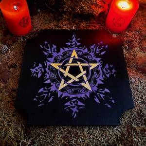 May include: A black wooden board with a purple and gold pentagram design. The board is surrounded by red candles and moss.