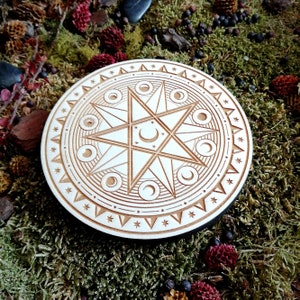 May include: A wooden circle with a carved design of a star with crescent moons around it. The circle is surrounded by a border of small stars.